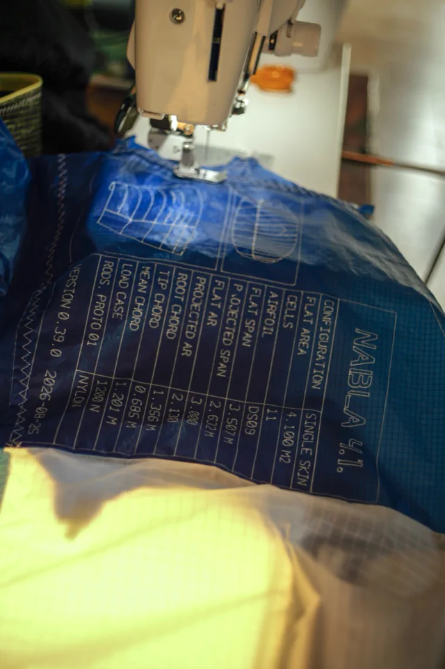 Étiquette du prototype imprimée sur le tissu ripstop bleu sous la machine à coudre